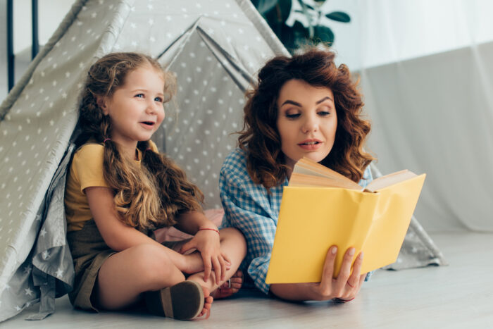 mom reading a chapter book out loud to her child