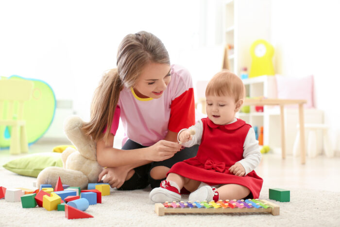 cute baby girl playing with babysitter