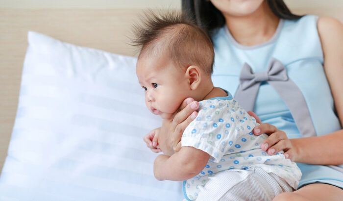 woman burping baby on back