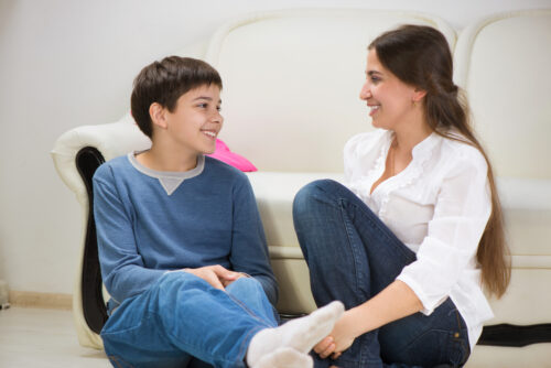 teen boy sitting and talking with his mother