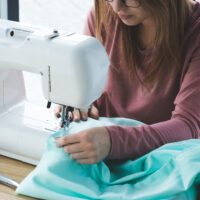 woman sewing fabric with a sewing machine