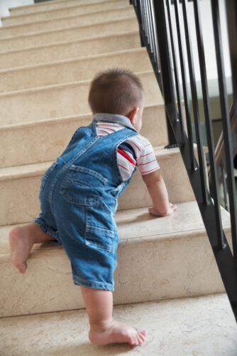 Baby boy crawling alone on stairs