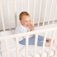 toddler sitting in crib