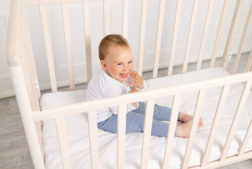 toddler sitting in crib