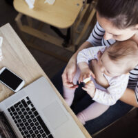 mom working from home with child on her lap