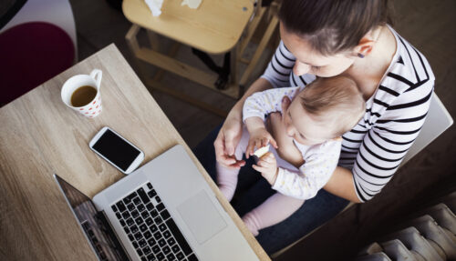 mom working from home with child on her lap