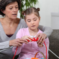 woman teaching a child to knit