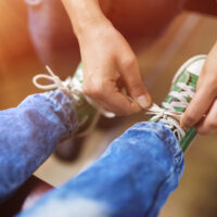 parent tying child's shoes