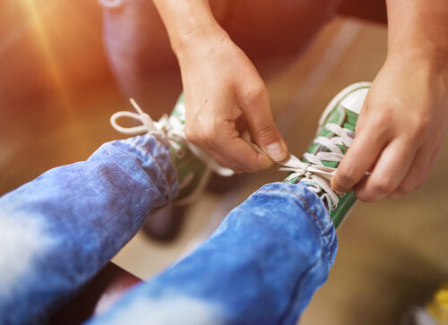 parent tying child's shoes